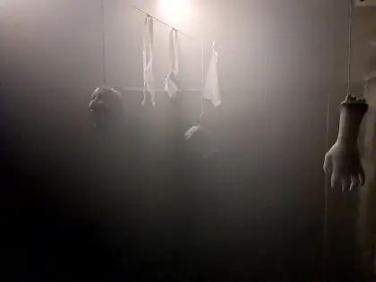 Nebelverhangener Raum, an einer Leine hängen Präparate und ein abgetrennter Arm